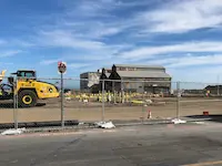Construction site with yellow excavator and bright blue sky